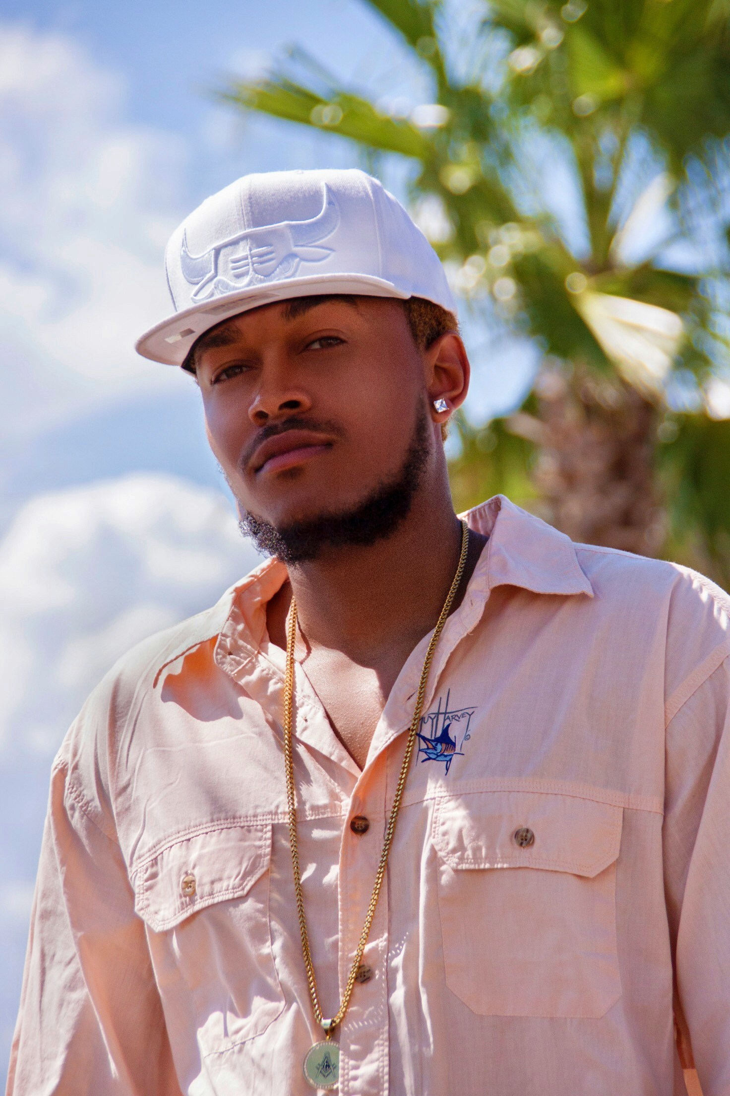 a man is wearing a white hat and posing for the camera