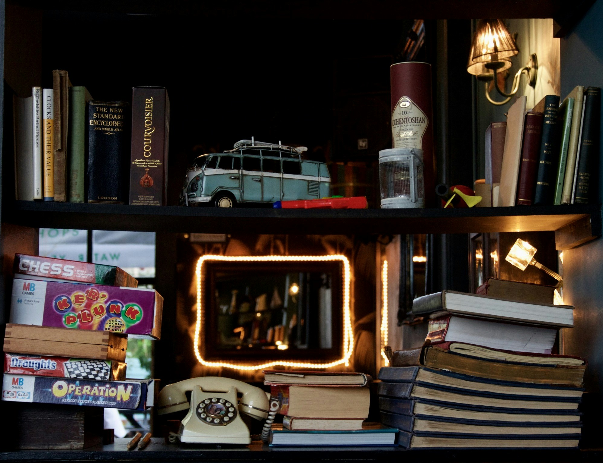 a book shelf filled with assorted books and a clock