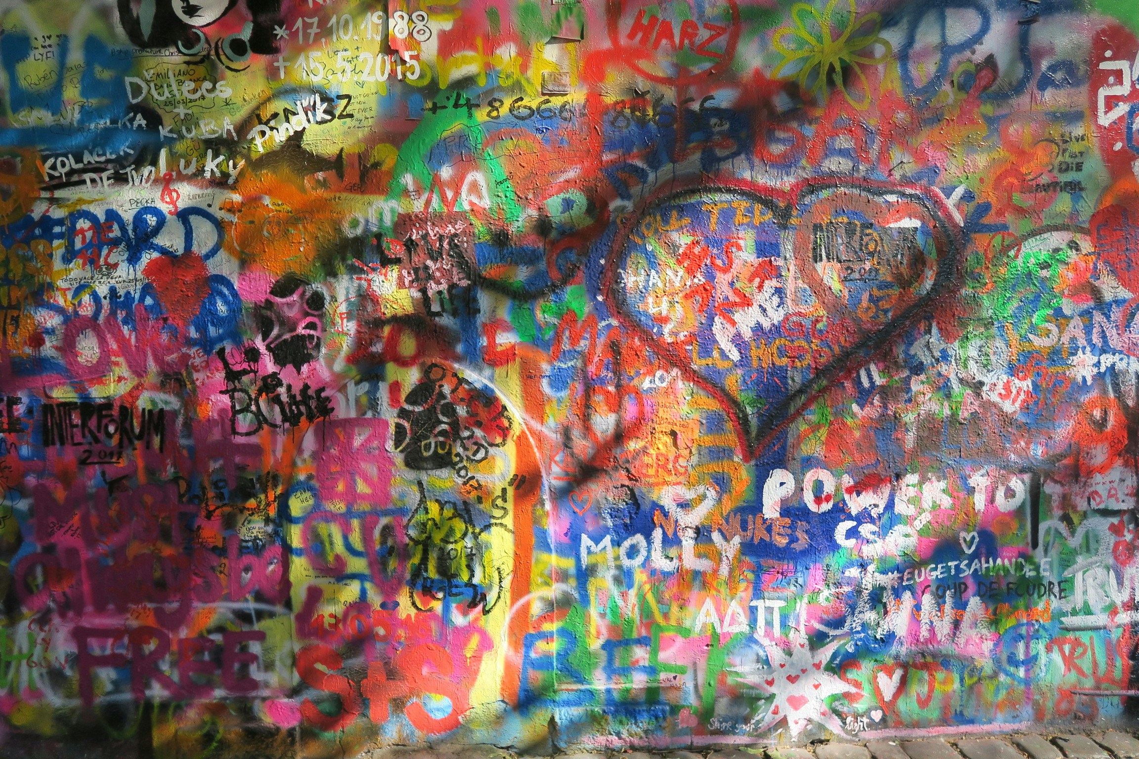 a wall covered in lots of colorful graffiti