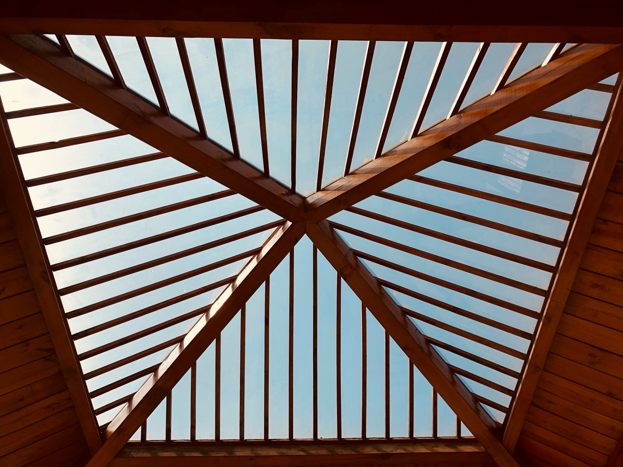 a view up into a building showing the roof and wood