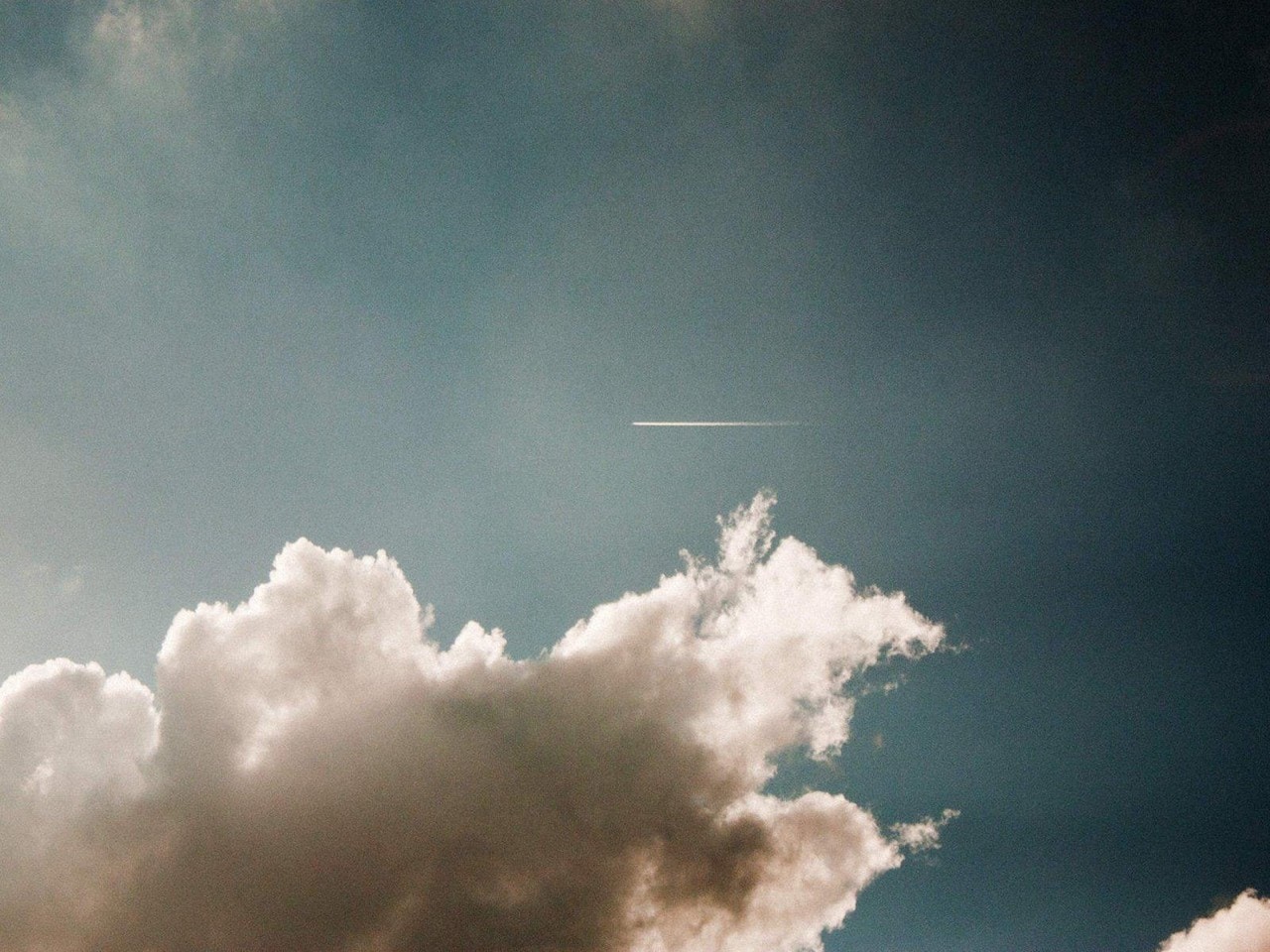 the airplane is flying by the cloud back into view