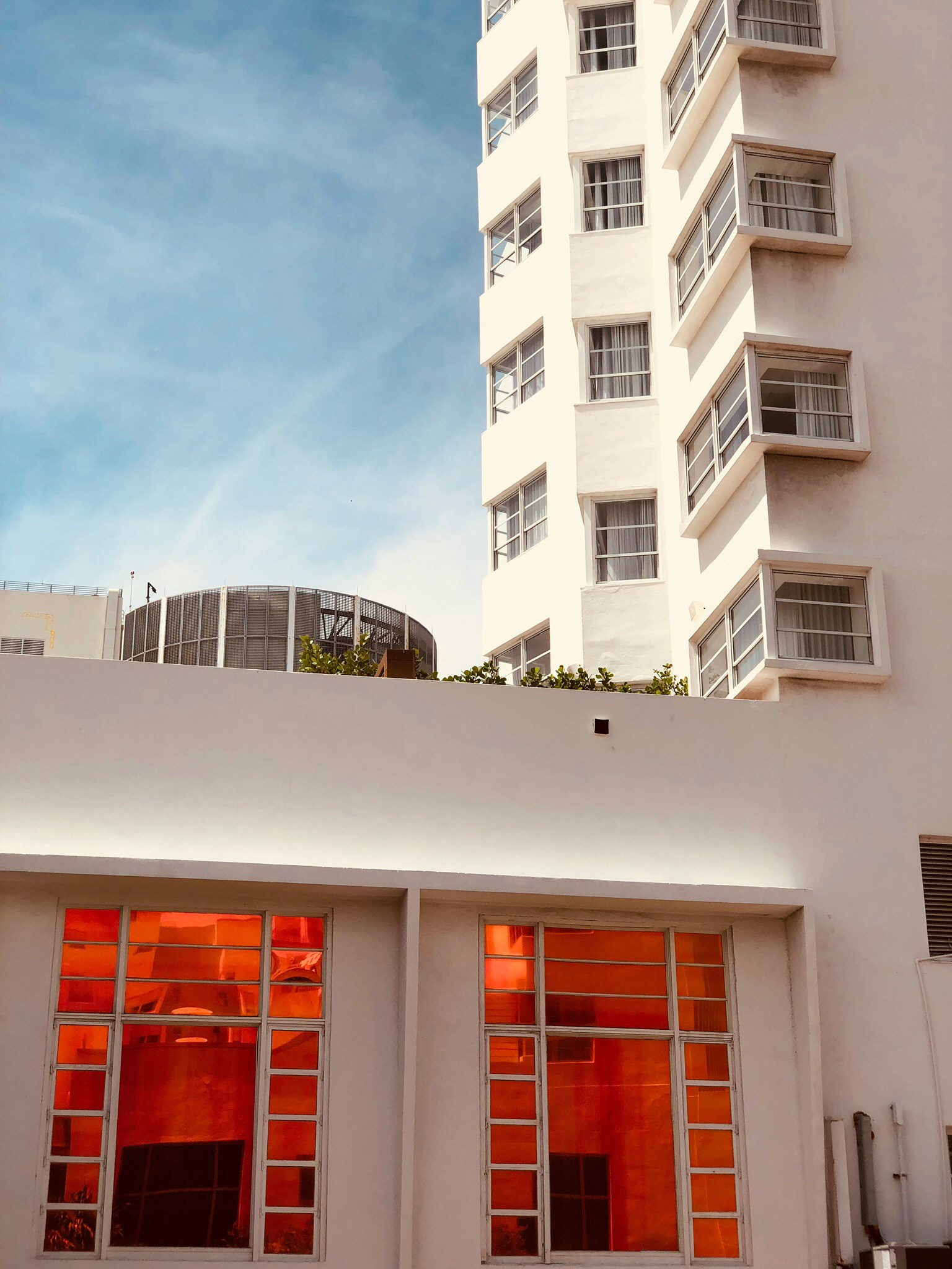 a tall white building is in the distance with orange windows