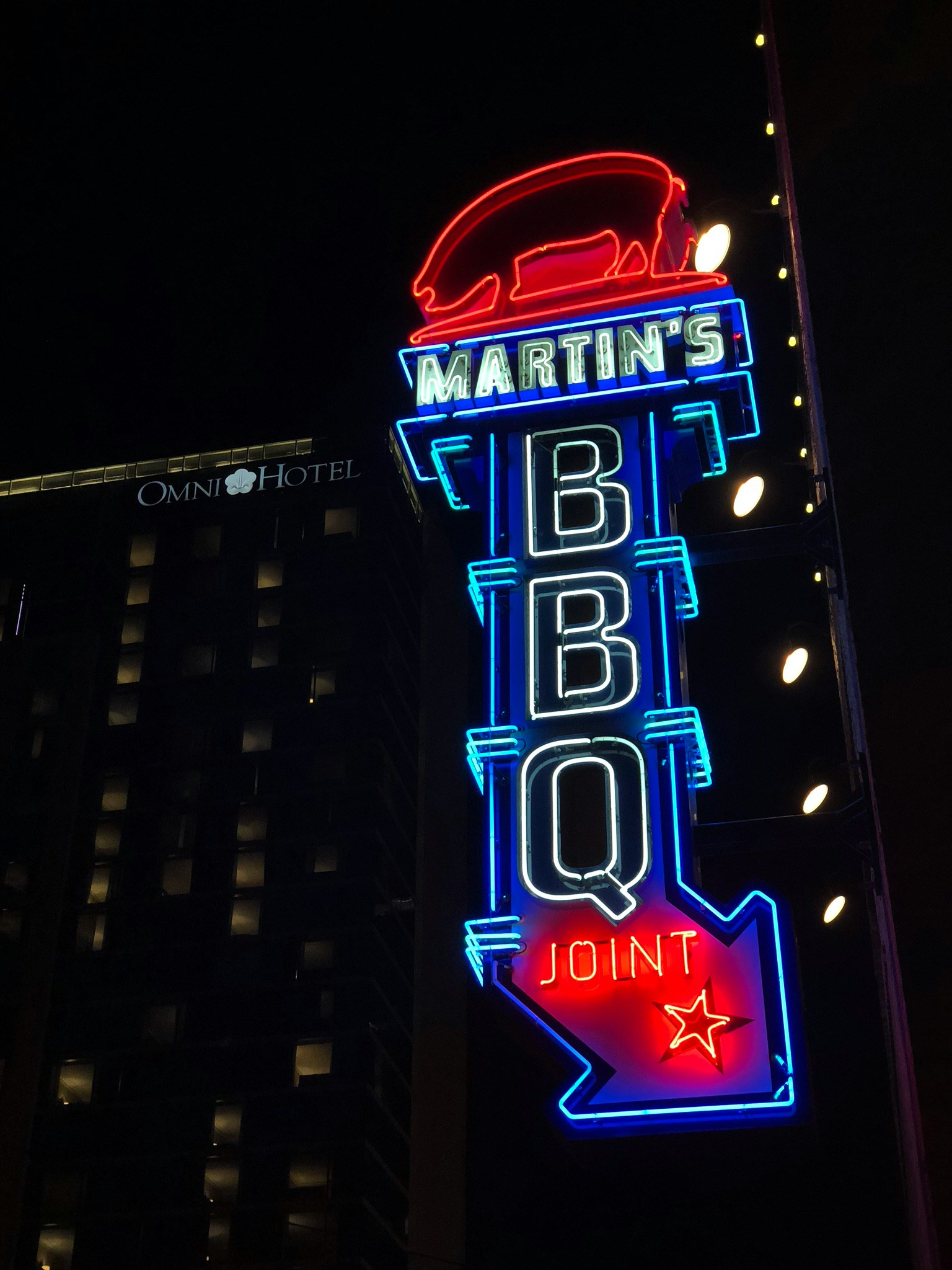 a building in the city at night lit up with lights and sign