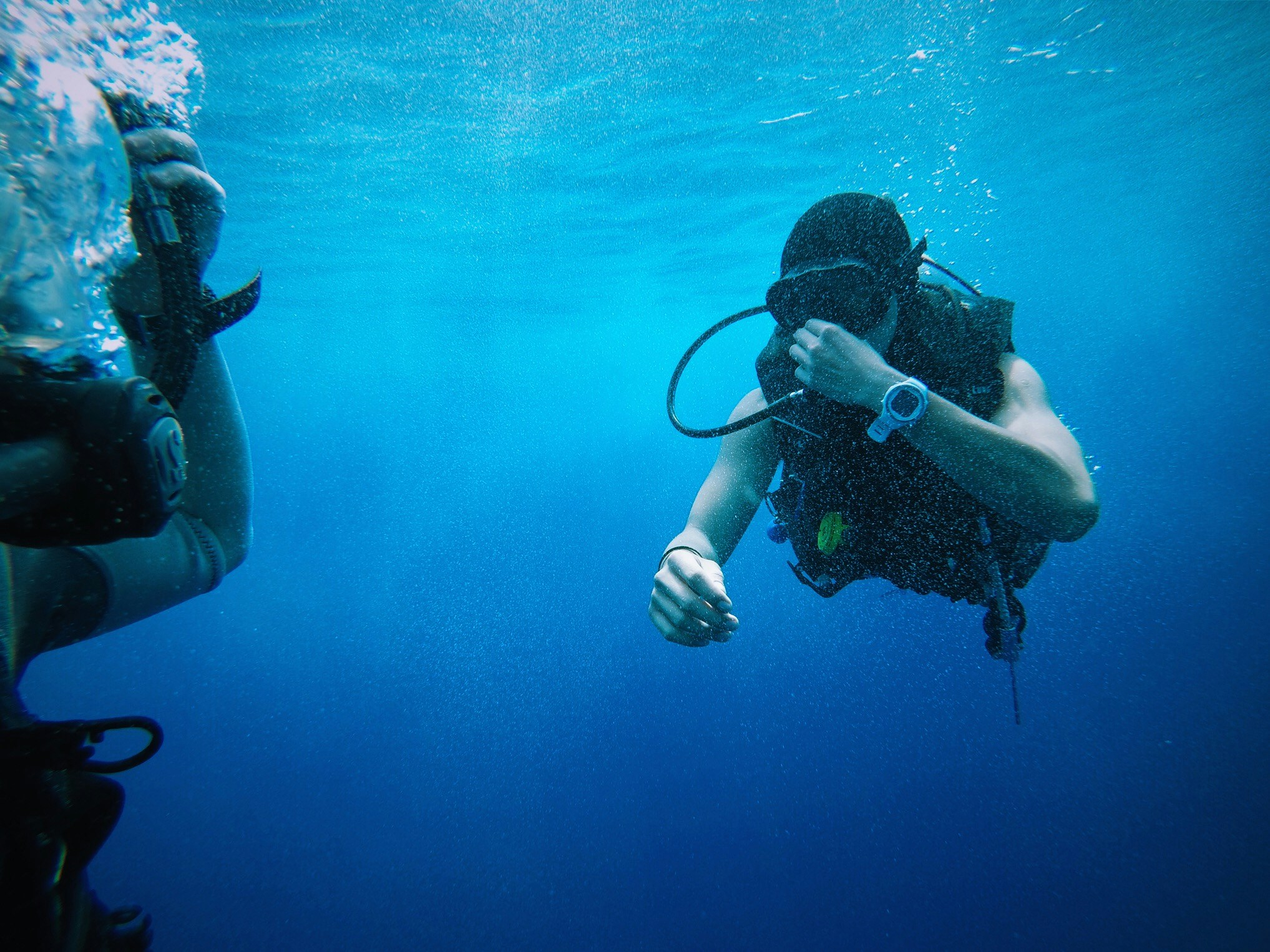 two people in diving gear looking at a camera