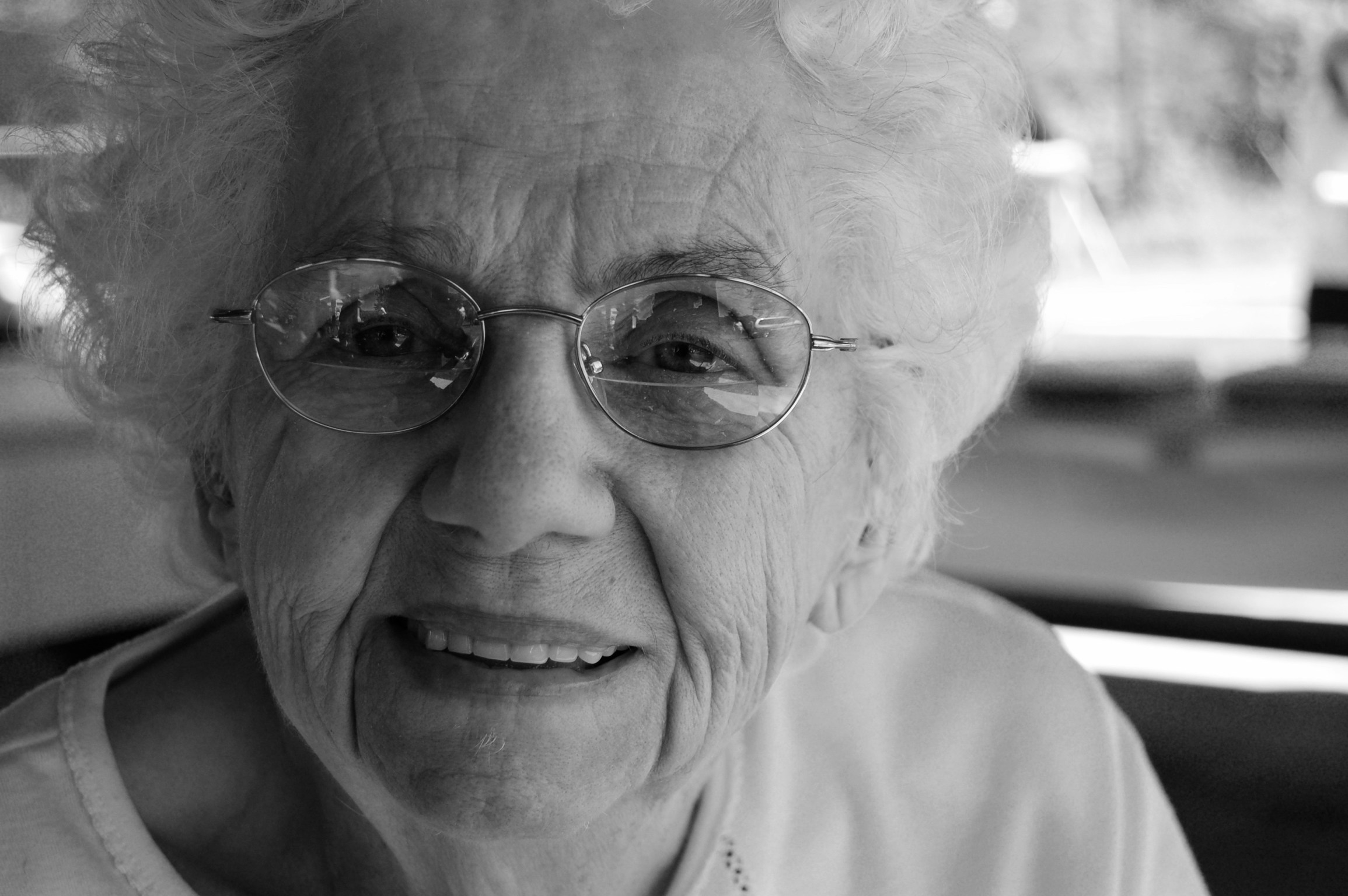 an old woman wearing glasses sitting down