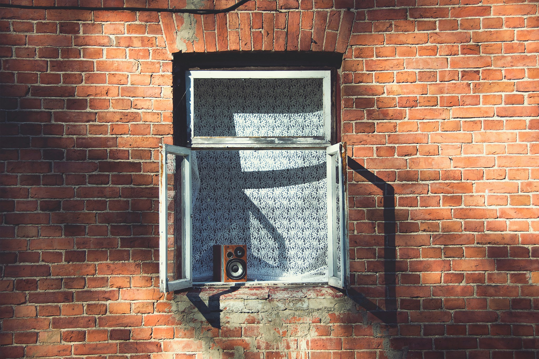 the shadow of a person's leg standing by a window