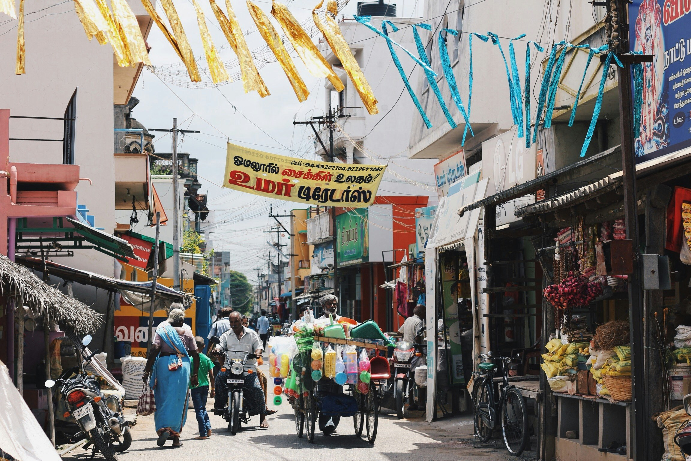 many people walking on a street with food on the rack