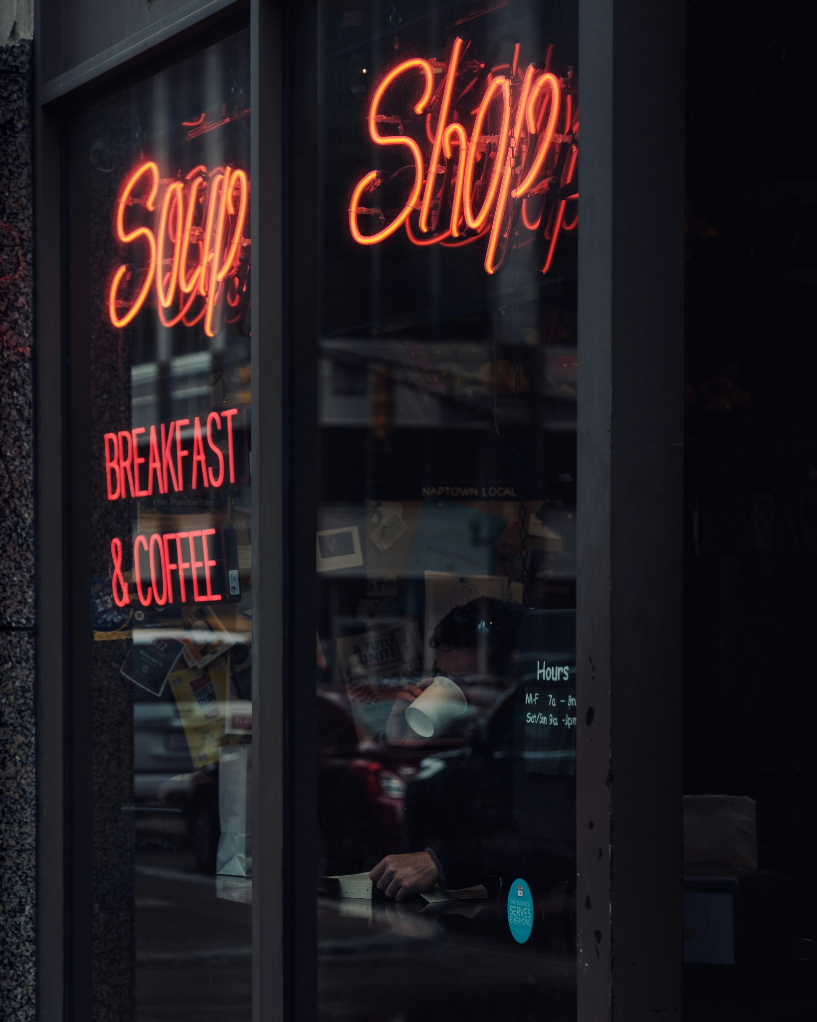 a person walks past the window of a coffee shop