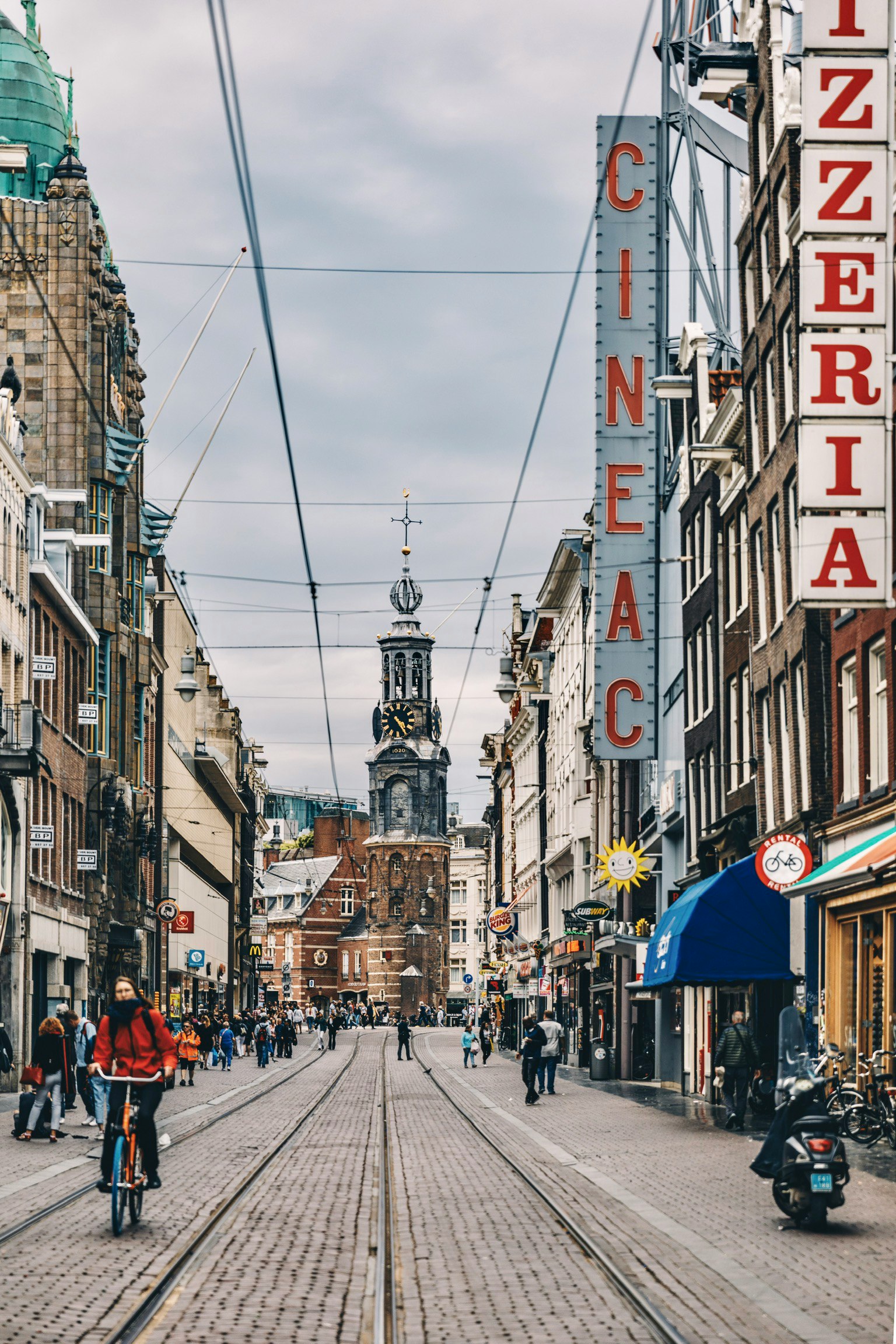 this is a city street with a clock tower in the distance